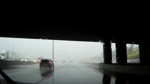 POV driving on highway in heavy traffic and torrential flooding rain storm Stock Footage