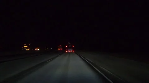POV driving plate on dark highway with car and truck traffic at night Stock Footage 149656997