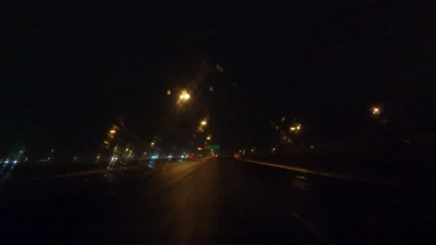 POV driving plate driving on a dark wet rainy night on city streets Видео 153294656