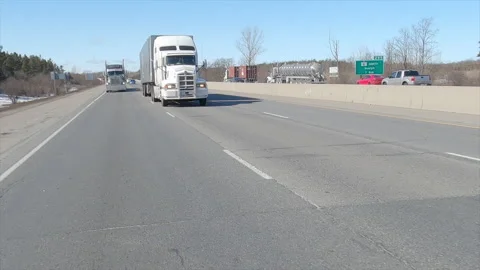 POV driving plate reverse shot tractor trailer trucks driving on highway Stock Footage 149897795