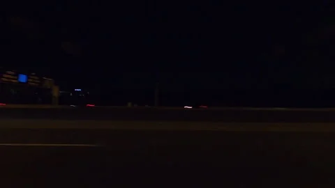 POV driving plate side view city streets on a very dark night Stockbeeldmateriaal 154223270