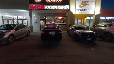 POV driving plate side view night city streets stores plaza dark Stock Footage 167296230