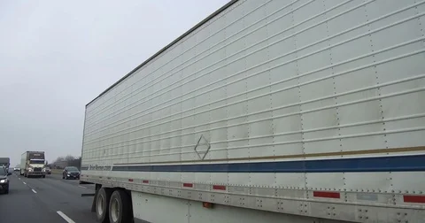 POV driving rear view on highway with tractor trailer trucks and car traffic Stock Footage 72802080