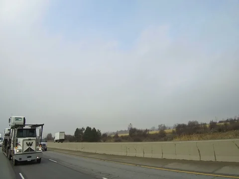 POV driving rear view on highway with tractor trailer trucks and car traffic Stock Footage 72804028