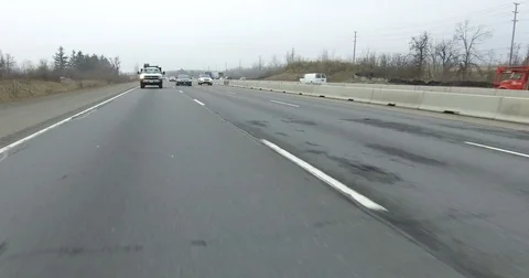 POV driving rear view on highway with tractor trailer trucks and car traffic Stock Footage 72809627