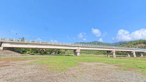 POV driving shot under a bridge onto a muddy, rough road. Stock Footage 339391315