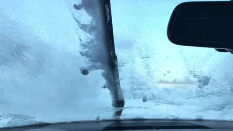 POV driving through deep snow with windshield icing over and wipers clearing Stock Footage 333308191