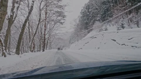 POV Driving Through Snow Covered Forest Road During Heavy Snowfall Winter Japan Stock Footage 336387765