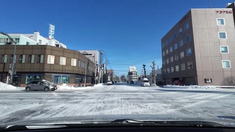 POV driving through snowy intersection with red light moment in Asahikawa Japan Vídeo Stock 333314022