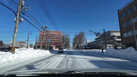 POV driving toward snowy intersection with traffic light in Asahikawa Japan Video stock 333314046
