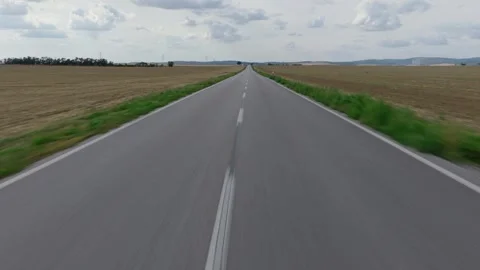 POV Drone Flight Along Empty Country Road Through Farmland Stock Footage 345296944