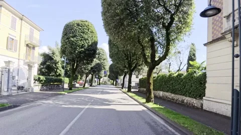 POV Elegant Tree Lined Boulevard Italian Villas Lake Garda Italy 4K HDR Stock Footage 331205333