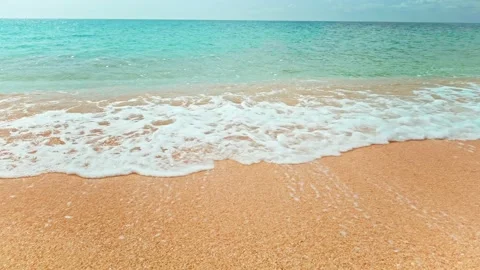 POV on empty sandy beach washed by crystal clear blue ocean in slow motion. Video stock 201194563
