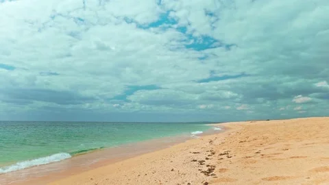 POV on empty sandy beach washed by crystal clear blue sea in slow motion. Stock Footage 209286399