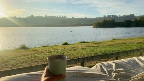 POV enjoying a coffee while looking out the back of a camper van at a stunning Stock Footage 320869989