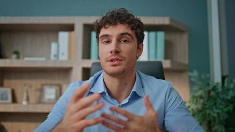 Pov entrepreneur talking camera interview in office. Online coach waving hand Stock Photos