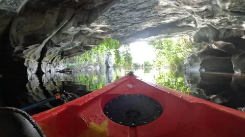 Pov exiting a cave on a kayak through Ivy Stock Footage 243593676