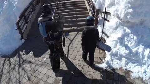 POV of a family walking with their snowboards at a ski resort. Stock Footage