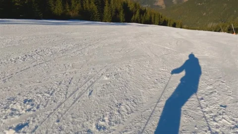 POV of Fast Skiing on Empty Slope with Skier Shadow in Winter Alps Resort Stock Footage 310668803