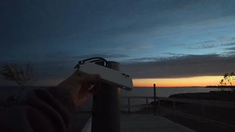 POV Finding Retrieving and Inspecting a Lost Phone Case Stuck in Metal Pole Video stock 325652056