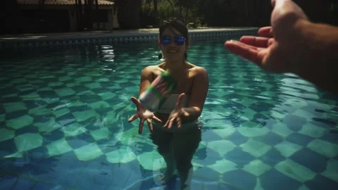 POV first person view throwing a can of beer at a woman in the pool and a friend Stock Footage 170021472