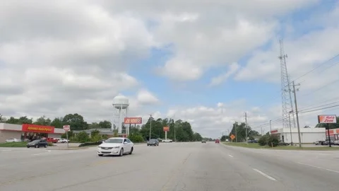 POV FPV driving cloudy sky urban scene people walking and on road Stock Footage 204947247