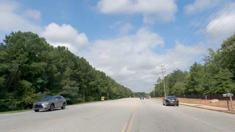 POV FPV driving cloudy sky urban scene retail stores Dollar General traffic T Stock Footage 204948282