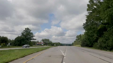 POV FPV driving cloudy sky passing Exxon gas station rural highway Hwy 1 Video stock 204948721