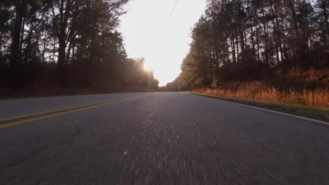 POV FPV driving down a rural country road at sunset low to the ground view wi Stock Footage 152379352