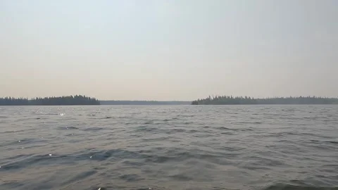 POV from the front of a canoe as it crosses a large lake with sparkling waves.  Stock Footage 254026131