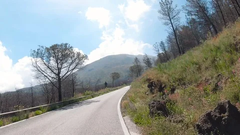 POV front view driving in curvy country road trees Mount Vesuvius in background Stock Footage 114280429