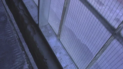 POV Going Down Industrial Elevator - Looking Out Grimy Window Down at Street Stock Footage 148122109
