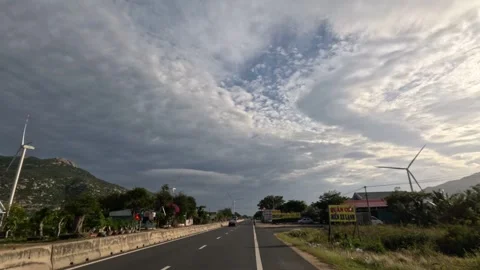 POV going on a motorway between windmill electric turbines in Vietnam Stock Footage 242137463