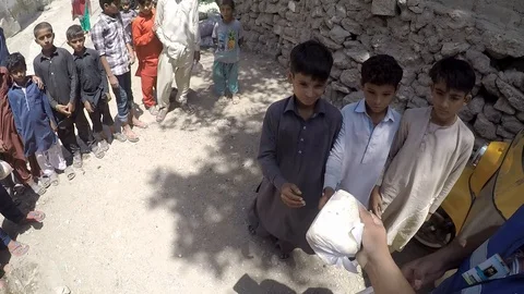 POV guy distributing food to poor children standing in line discipline to mainta Vídeo Stock 129177142