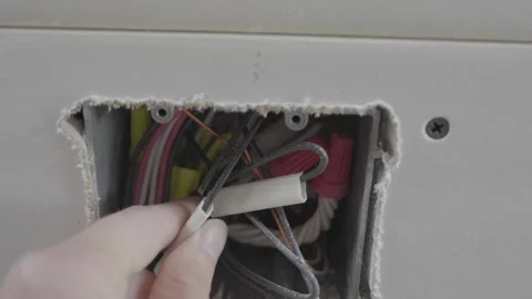 POV hand checking outlet wires Stock Footage 303641335