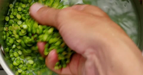 POV. Hand washes peas in the kitchen stainless steel pot. Stock Footage 268940952