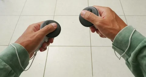 POV of hands holding white controllers, plays in virtual reality. Video stock 257584093