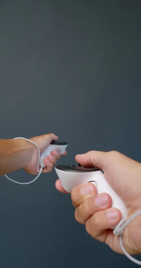 POV of hands holding white controllers, plays in virtual reality. Stock Footage 257683774