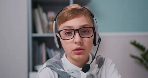 POV of happy kid doing work interview meeting online. Boy sits in modern living Stock Footage 232005205