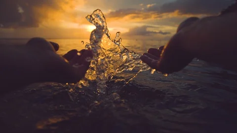 POV Having fun on the beach splashing crystal clear ocean water over the sunrise Stock Footage 92016930