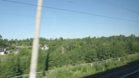 POV: High-speed Train moves past a forest and small homes in the summer Stock Footage 80460555