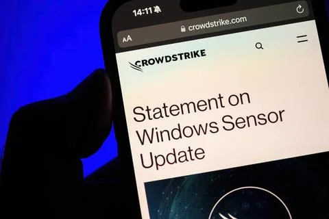 POV: Holding iPhone with CrowdStrike Statement on Windows Sensor Update Fotos de archivo
