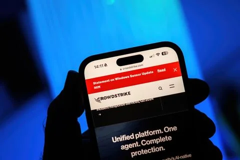 POV: Holding iPhone with CrowdStrike Statement on Windows Sensor Update Foto stock