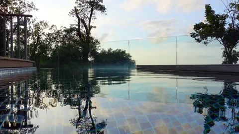 POV infinity pool edge from high trees view of tropical luxury resort pool Stock Footage 145271927