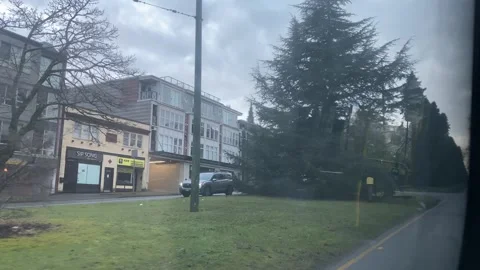 POV inside bus view of road cars trees on cloudy day Stock Footage 302480090
