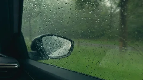 POV Inside Car on Rainy Drive with Droplets Sliding on Window and Wet Side Stock Footage 337438776
