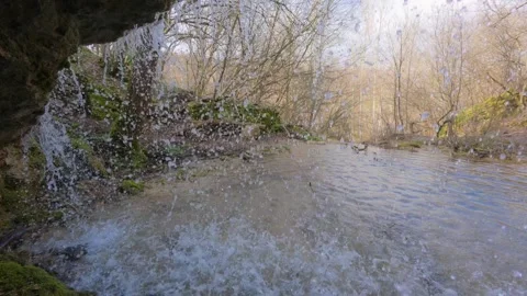POV inside a waterfall, close-up of water drops falling from a rocky ledge in fo Stock-Footage 330120451