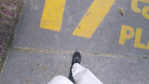 POV Looking Down at Feet Walking from a Concrete Path onto Green Grass in a Park Stock Footage 329798314