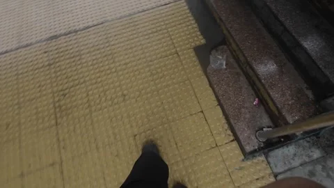 POV Looking Down at Foot Walking on Yellow Tactile Paving on Urban Sidewalk. Stock Footage 340991758