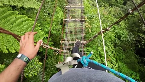 POV Looking Down on Narrow and Small Steel Suspension Bridge Stock Footage 247164488